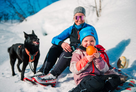 En barn som holder en appelsin på skitur