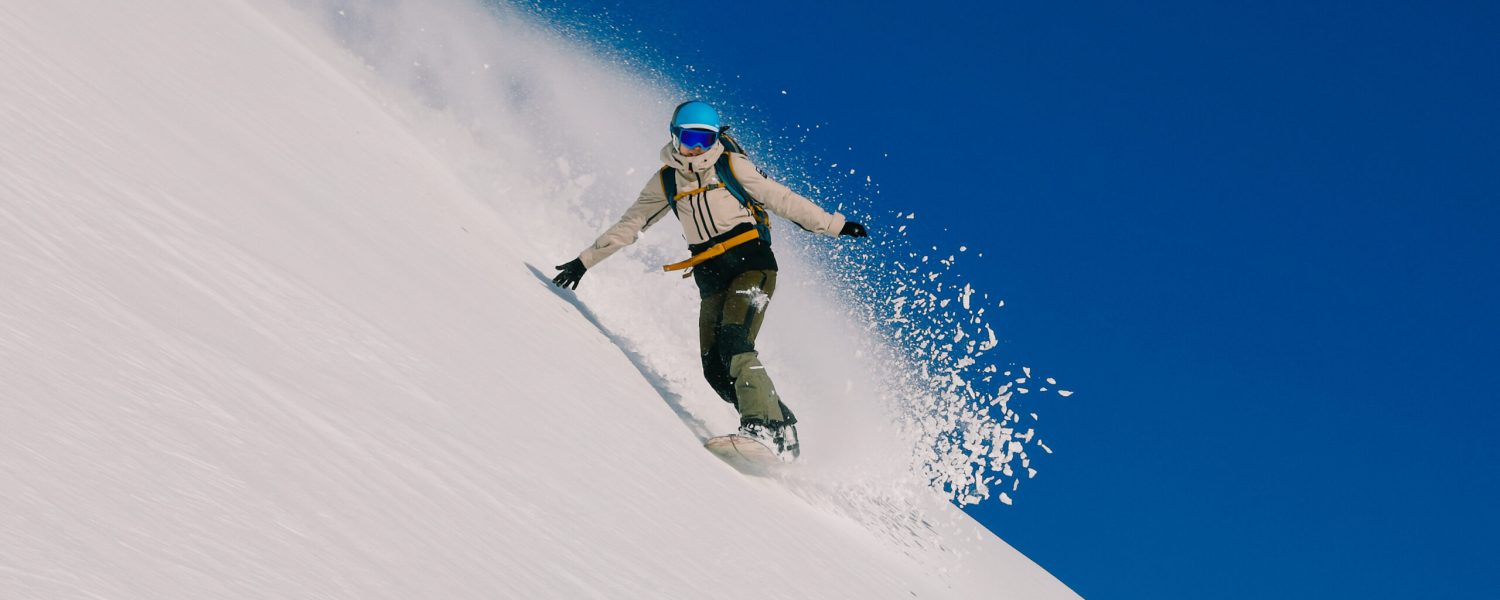 Snowboarder som kjører i puddersnø